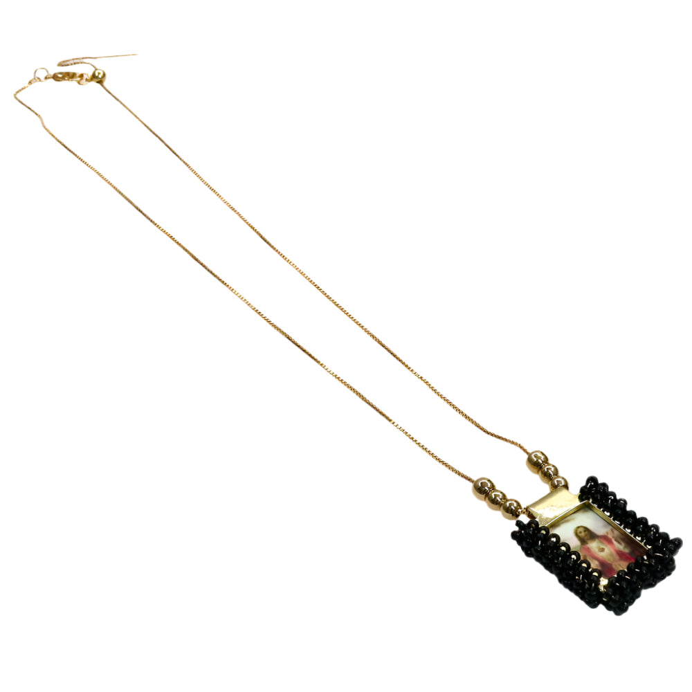 Gold religious escapulario chain necklace with a framed religious image pendant and black bead accents