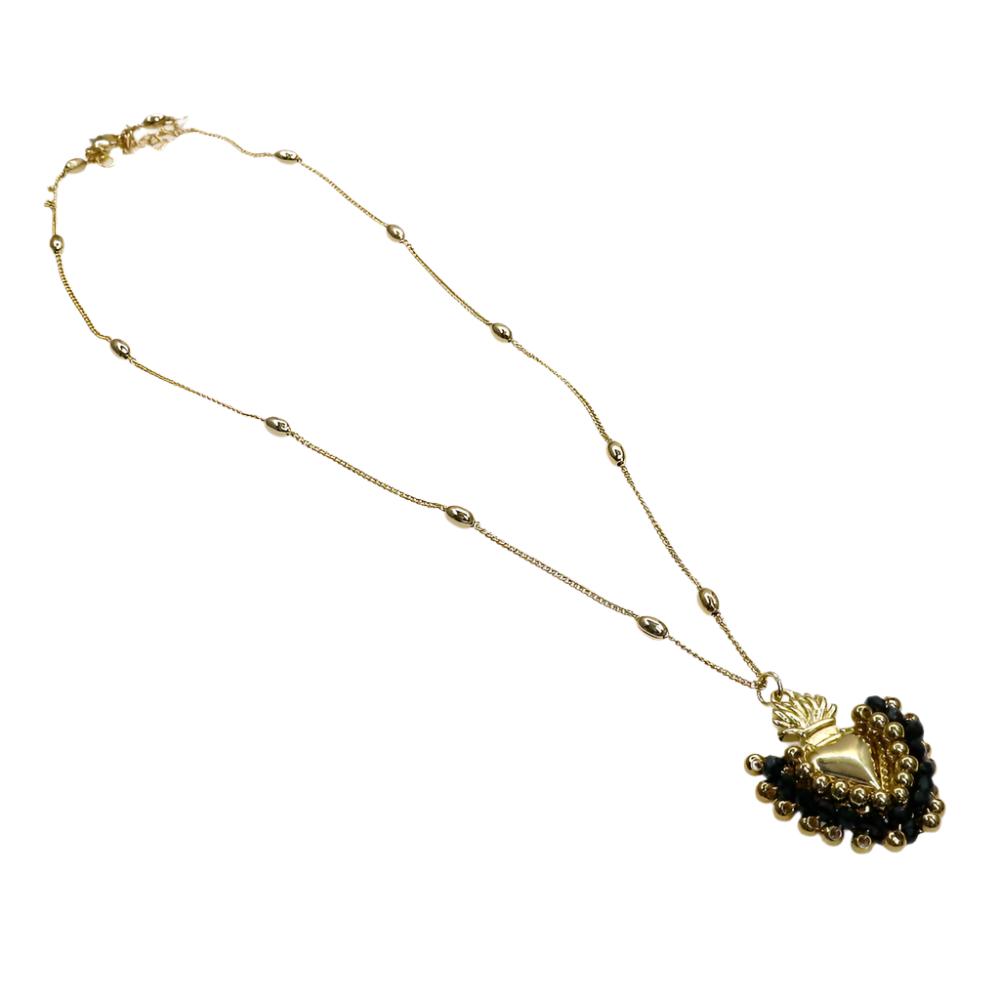gold chain necklace with intricate beads and heart-shaped pendant surrounded by black and gold accents