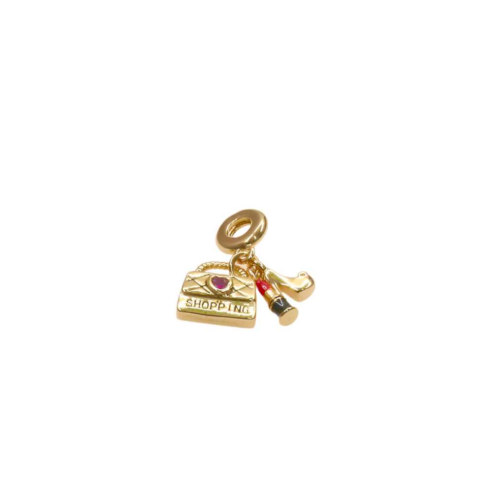 Delicate gold shopping bag and lipstick charm accessory for subtle elegance and style