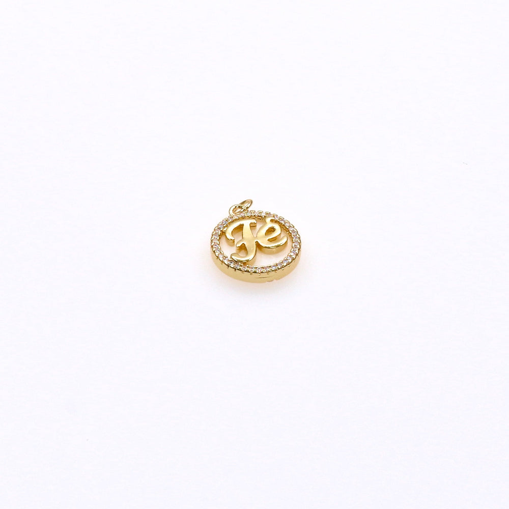 Gold circular pendant charm with "fe" script and crystal border, elegant accessory