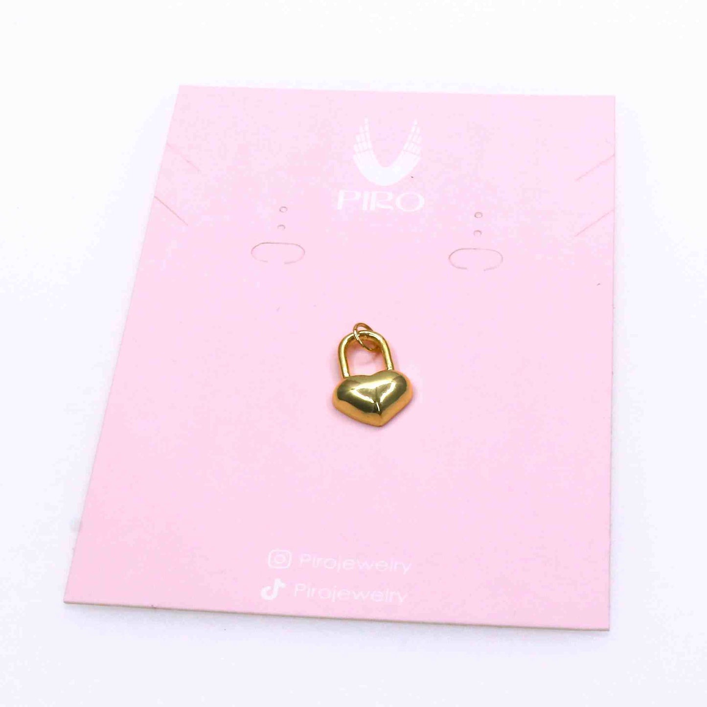 Gold heart-shaped lock love charm on pink jewelry card