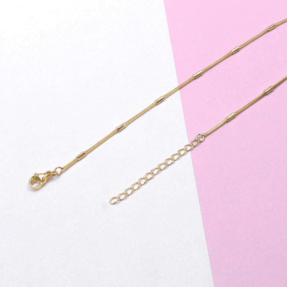 Gold-toned Rabit Tail Chain necklace with adjustable links on pink and white background
