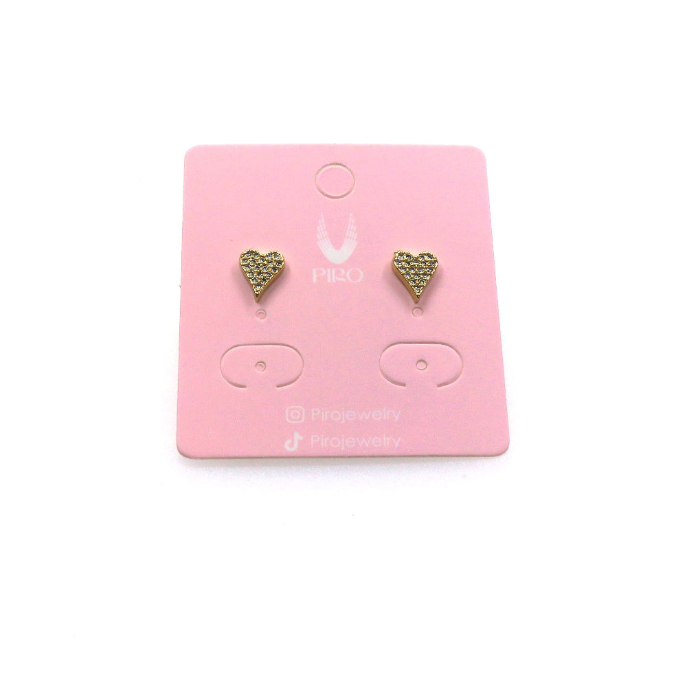 Gold heart-shaped stud earrings on a pink jewelry card