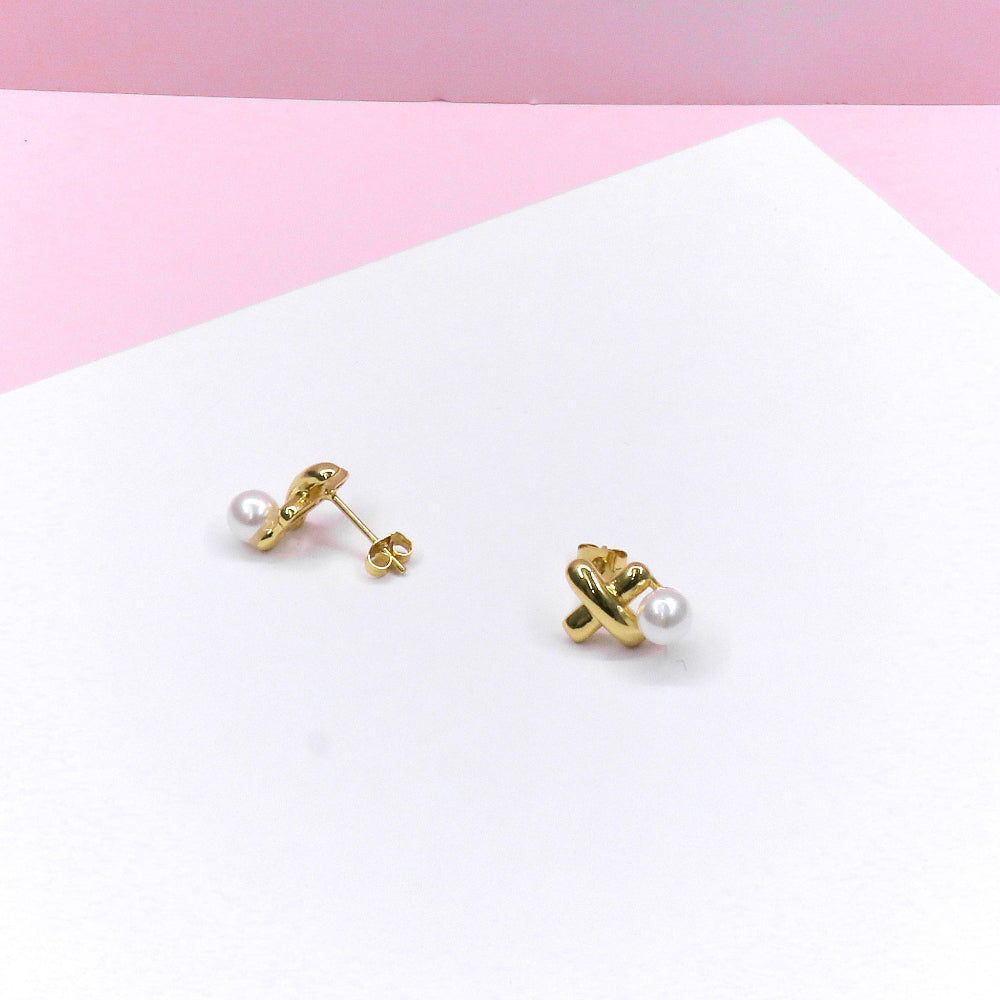 gold X Pearl Stud Earring on white and pink background