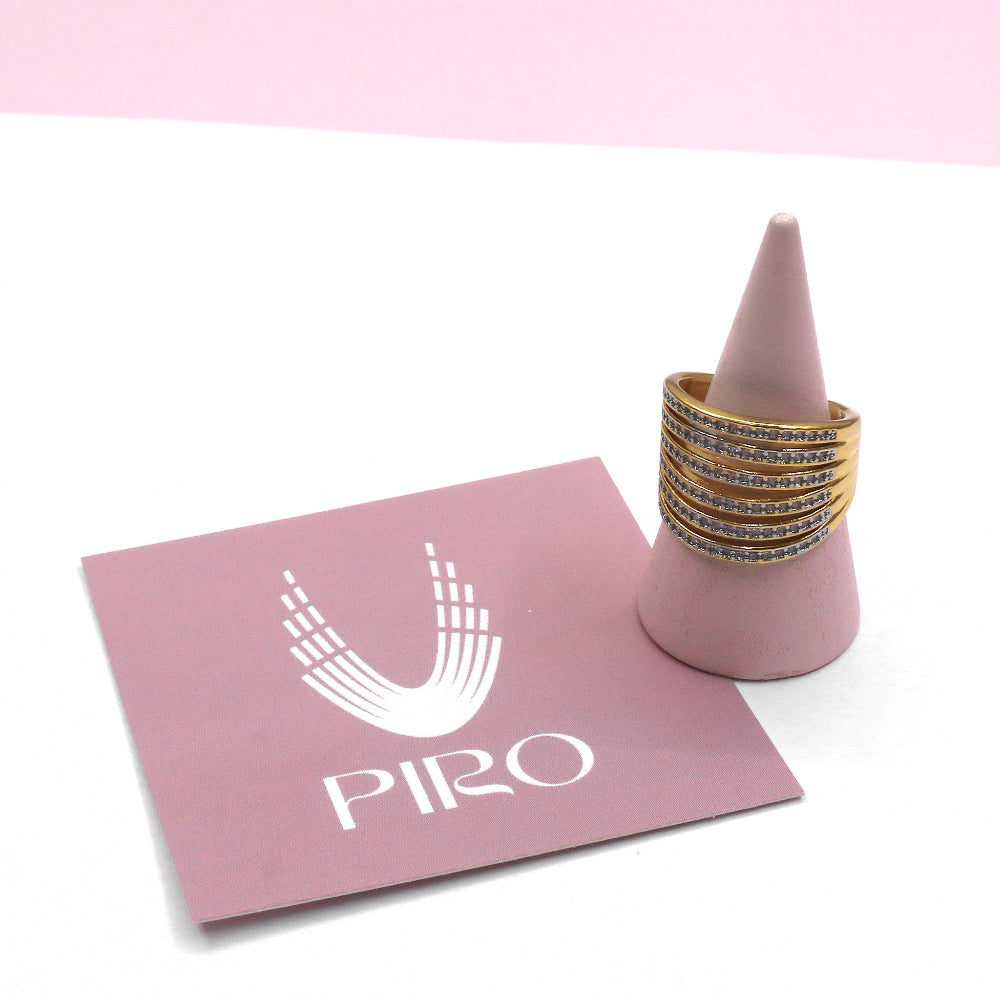 Adjustable gold fashion ring with mini pave crystals displayed on pink cone stand by PIRO logo card