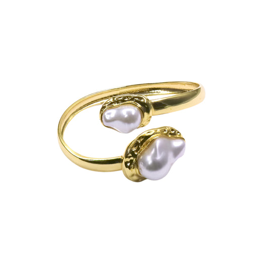 Gold open-toe ring with pearl accents on a white background