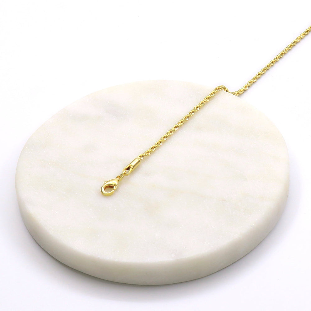 Delicate 7-inch tinny rope golden bracelet on white marble display stand