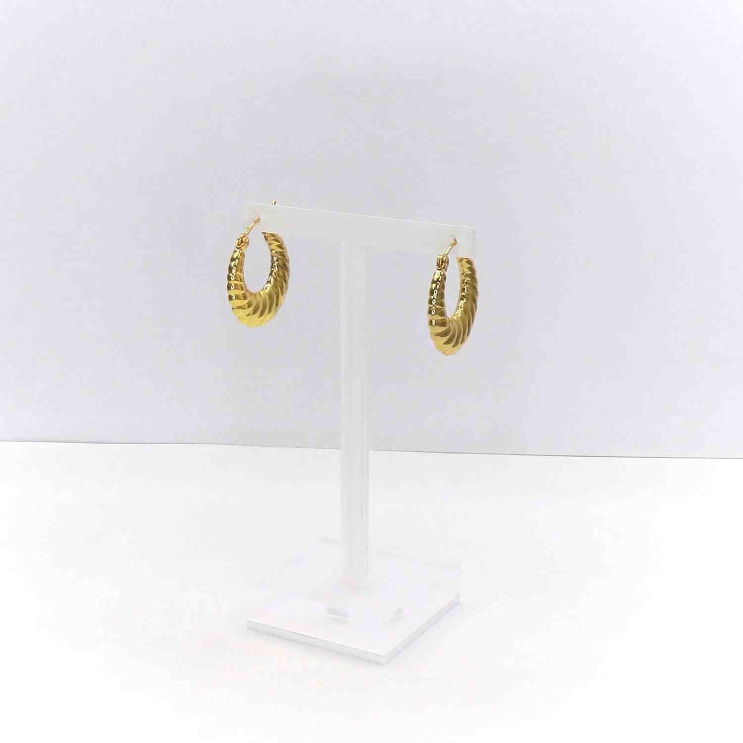 Gold filled croissant shaped hoop earrings on clear stand
