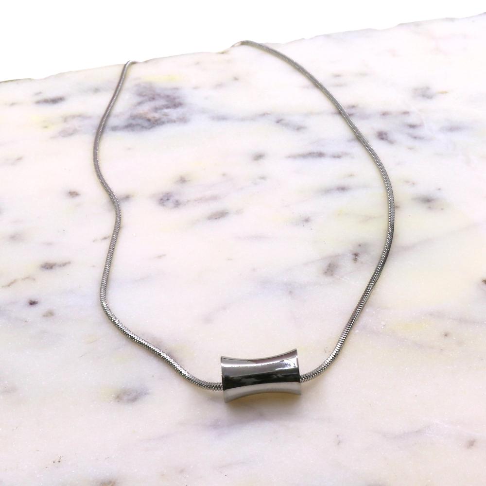 Stainless steel Cylinder CHAIN necklace with polished cylindrical pendant on marble surface