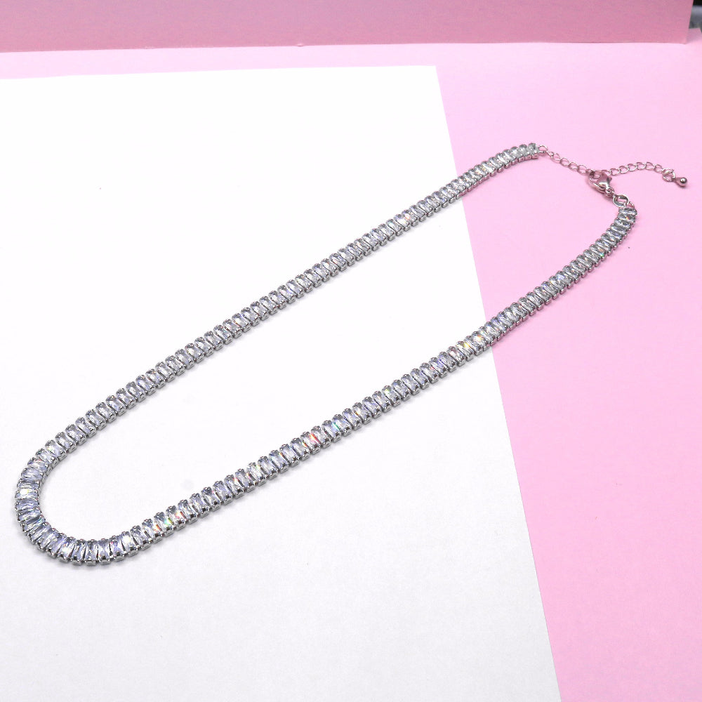 16 inch silver tennis chain necklace with sparkling gemstones on pink and white background
