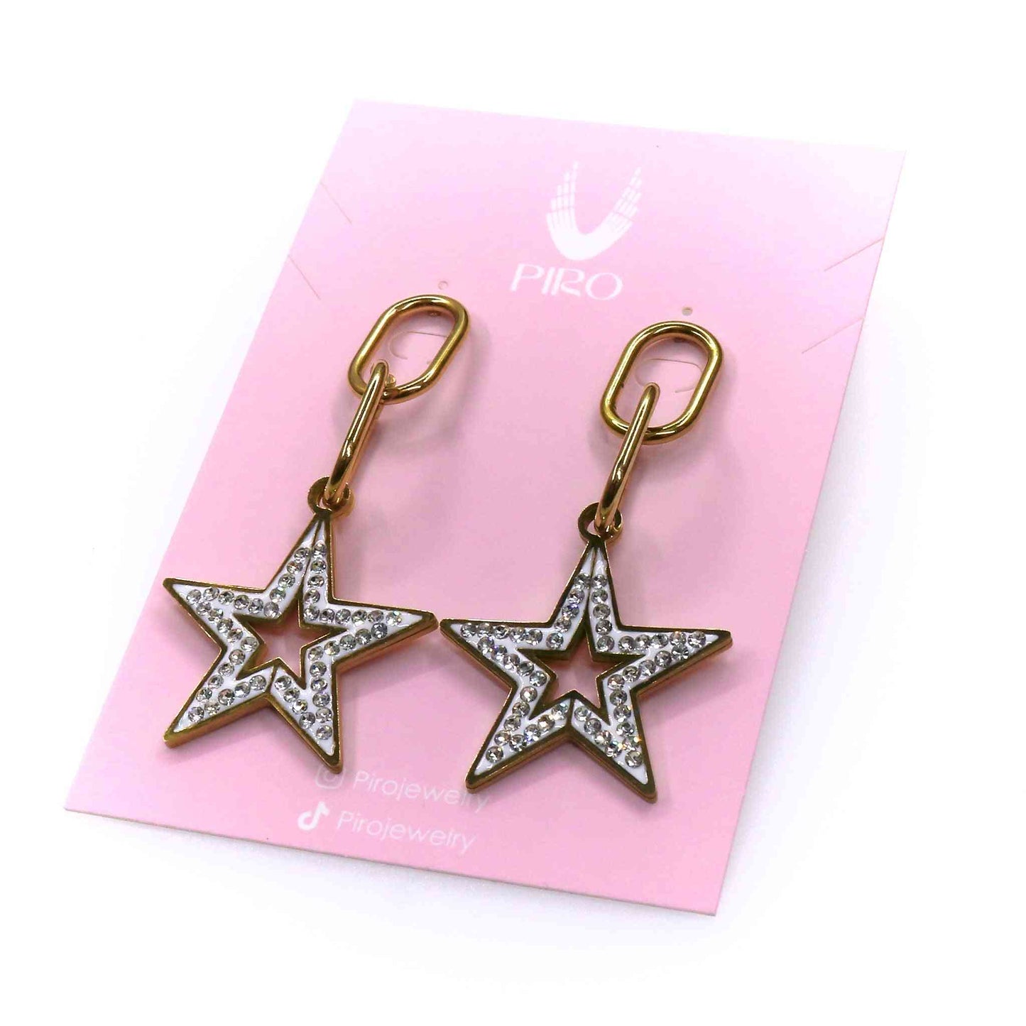 Gold star-shaped long earrings with embedded crystals on pink jewelry card