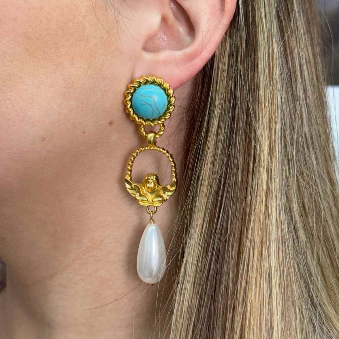 Gold-filled Sinfonia earring with turquoise stone and pearl drop worn on ear