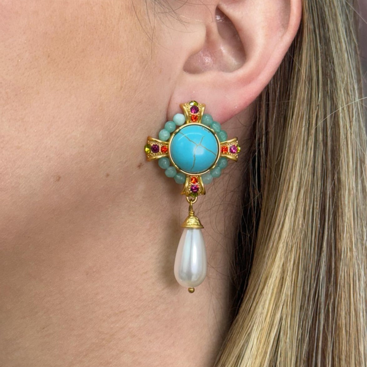 Vintage-inspired Reina earring with gold fill, turquoise center, pink gemstones, and dangling pearl drop worn on ear