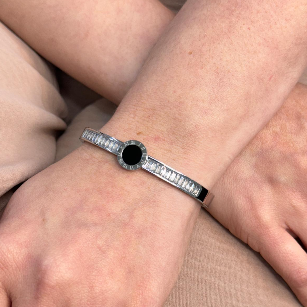 Baguette diamonds steel bangle with black resin Roman numeral detail on wrist