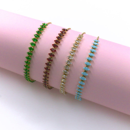 Set of four slider bracelets with green, red, clear zirconia stones, and blue beads on gold bands