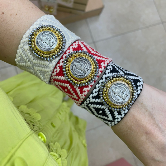 Handmade San Benito bracelets with fabric bands in white, red, and black, featuring iconic medallions and beaded embellishments.