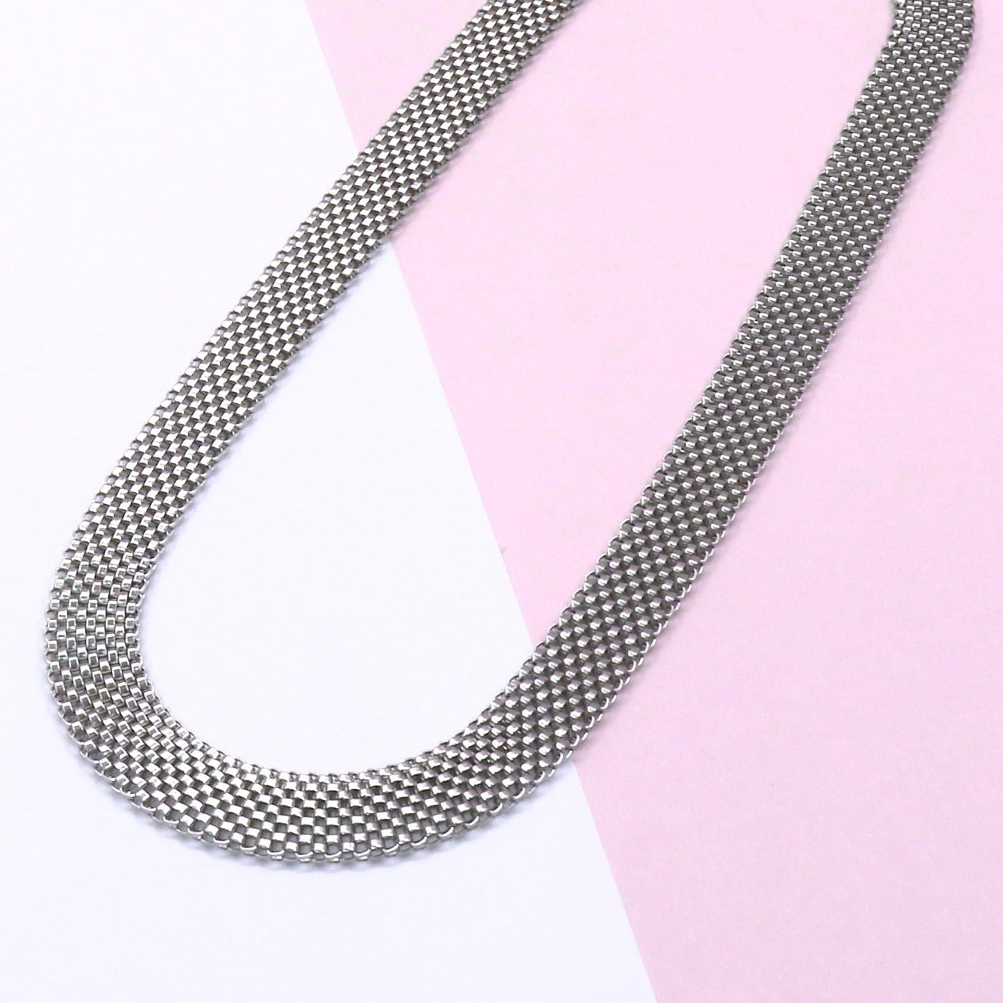 Stainless steel MILAN CHAIN omega necklace with sleek, durable design on pink and white background