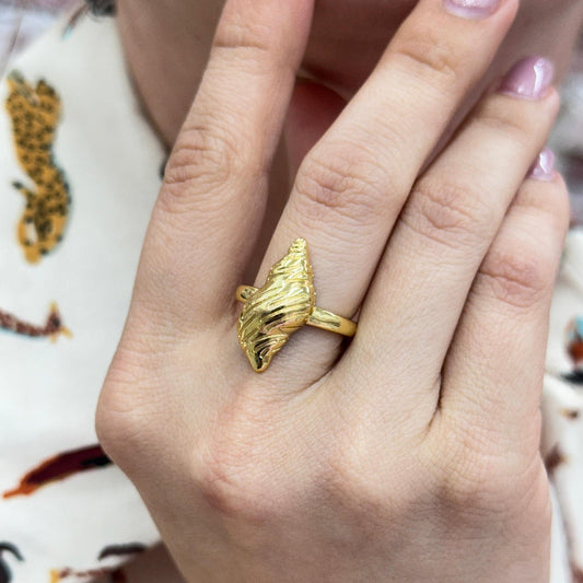 Gold-filled Osean Caracol Ring with ocean-inspired shell design on finger, adjustable size, elegant and durable jewelry piece.