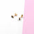 MINI SQUARE STUD earrings with modern design on pink and white background.
