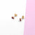 MINI SQUARE STUD earrings with modern design on white and pink background.