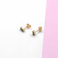 Mini square stud earrings on a white and pink surface, showcasing their elegant and modern design.