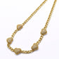 Gold necklace with heart-shaped pendants on a white background