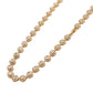 Gold necklace with diamond-like stones on a white background