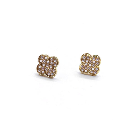 Gold earrings with pearl-like stones on a white background