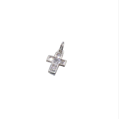 Silver cross pendant with clear stones on a white background