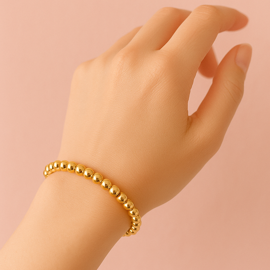 gold beads elastic bracelet on wrist with gold-filled round beads for adjustable fit and elegant style