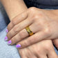 Braided gold ring on hand showcasing intricate design and elegance.