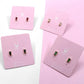 Mini square stud earrings in assorted colors on display cards.