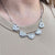 LOVE CHAIN with solid heart charms on a stainless steel golden and silver chain.