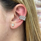 Close-up of an ear wearing a silver and gold tone gold-filled Beads Pave Cuff earcuff and a small gold earring with a clear stone.