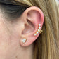 Close-up of an ear with pearl and crystal earrings.